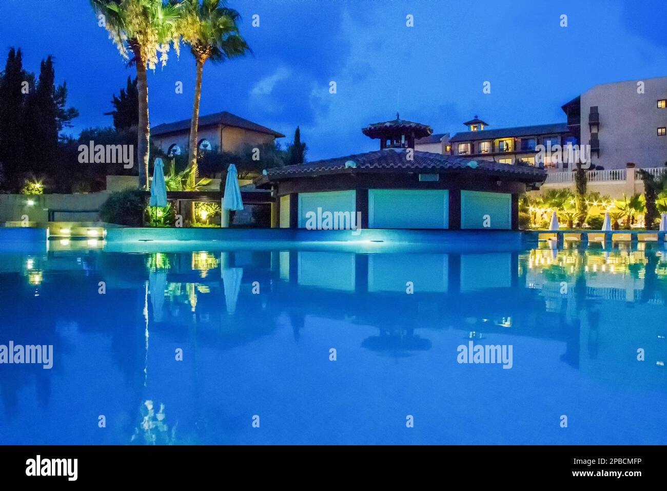 Paradise Garden and pool  in 5-star hotel of Greek islands or Cyprus island and amazing skyscape in  blue time with pink-blue sunset and some kiosk wi Stock Photo