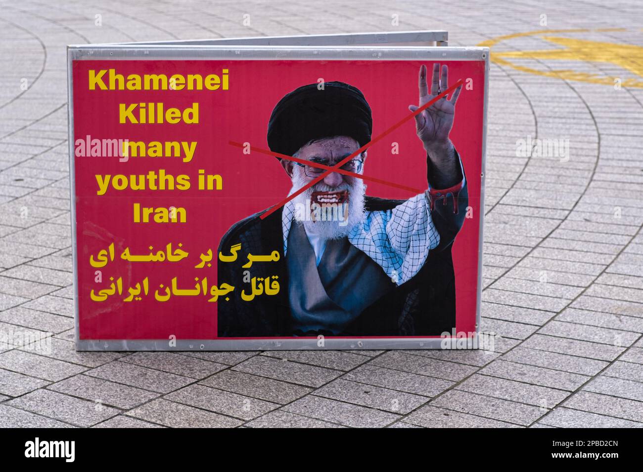 Anti Khamenei poster in Trafalgar Square - activists protest in London against the Iranian Regime because of their murderous regime. Stock Photo