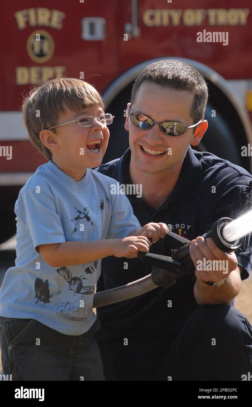Andy Vonderembse of the Troy Fire Department assists Braedon Erwin with