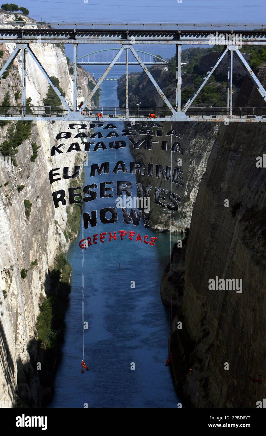 Greenpeace activists hang a giant banner over the Corinth canal