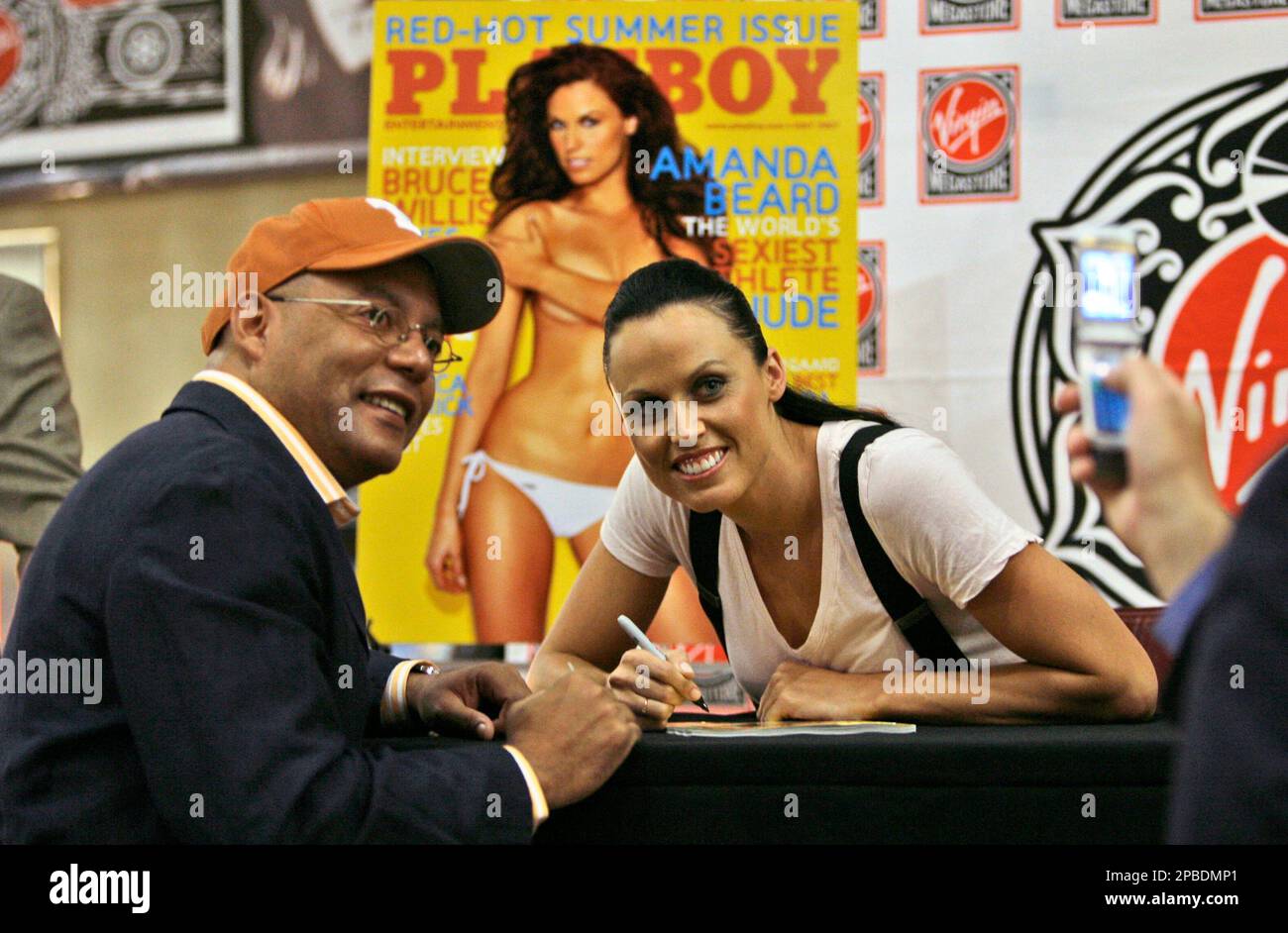 Olympic medalist Amanda Beard, right, poses for a cell phone photo with  Samuel Johnson, of Punta Cana, Dominican Republic, after signing his copy  of the July issue of Playboy magazine during a