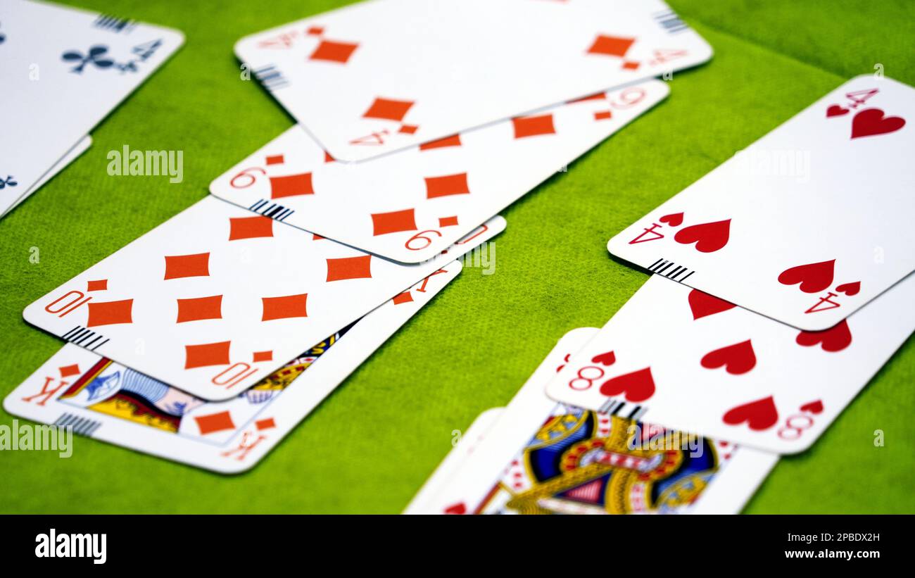 Bridge cards on a green card table Stock Photo
