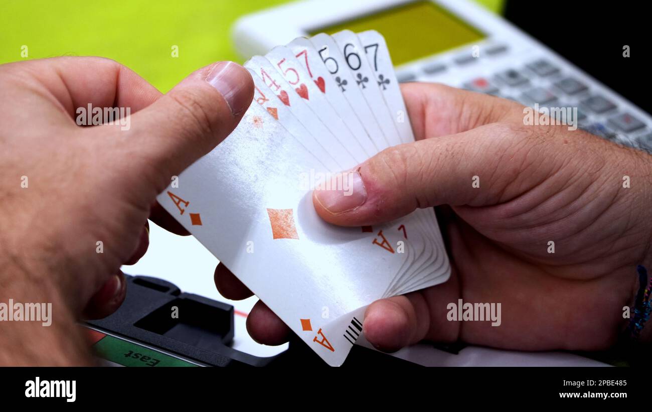 Playing cards in a man's hand during a bridge game Stock Photo