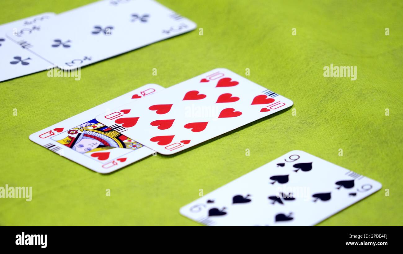 Bridge cards on a green card table Stock Photo
