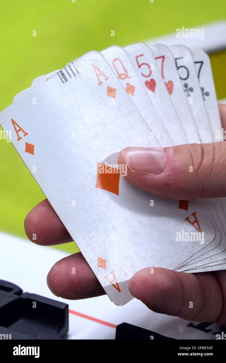 Playing cards in a man's hand during a bridge game Stock Photo