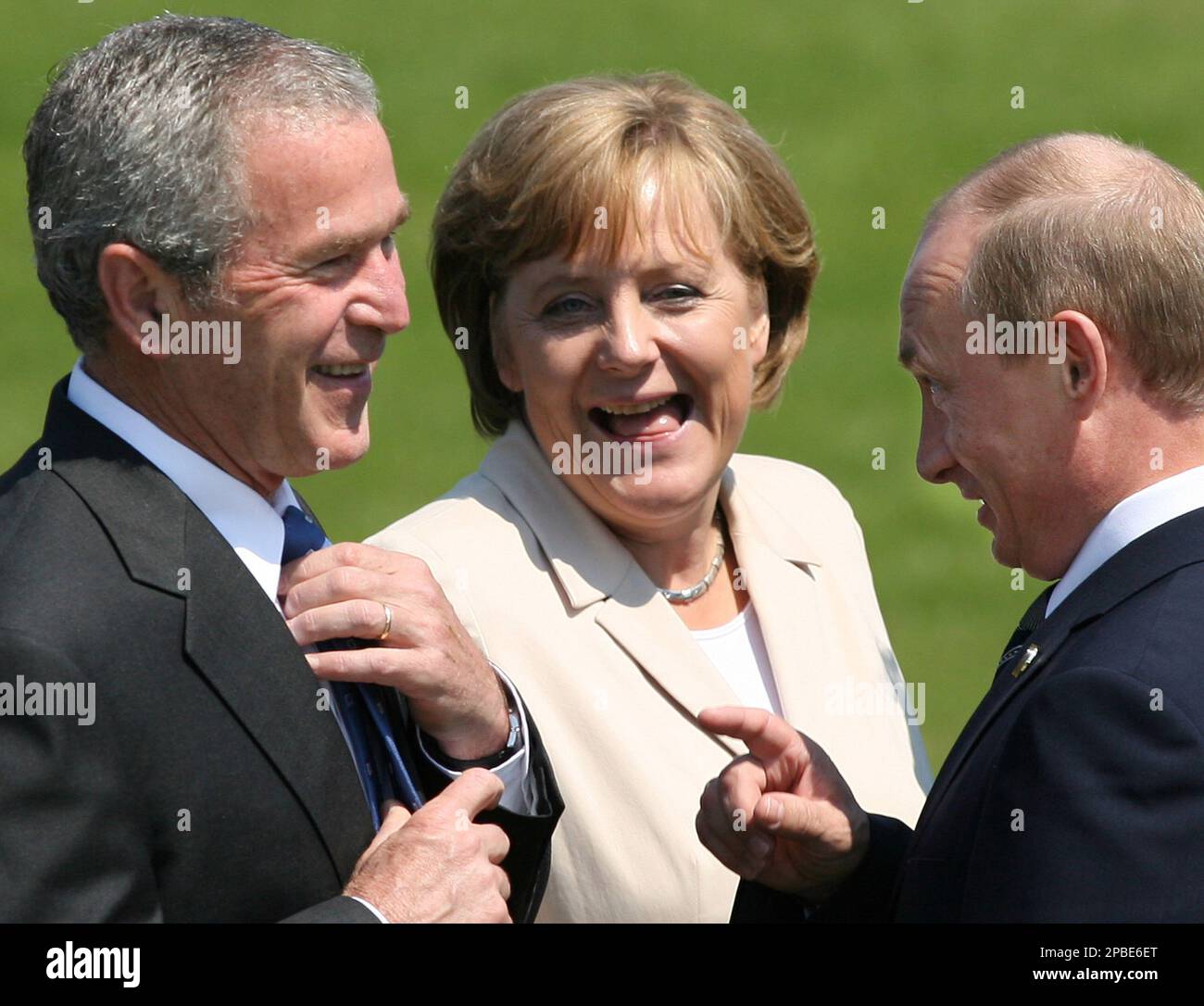 U.S. President George W. Bush, left, Russian President Vladimir Putin, right, and German Chancellor Angela Merkel, center, share a light moment prior to the family photo session with Outreach countries at G8 summit in Heiligendamm, on Friday June 8, 2007. (AP Photo/Toshifumi KITAMURA, POOL) Stock Photo