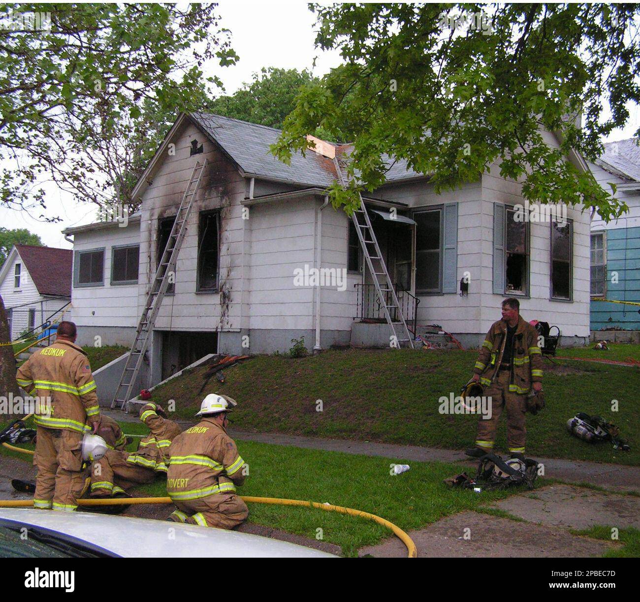 ** FILE ** Firefighters are shown outside of the fire damaged home in