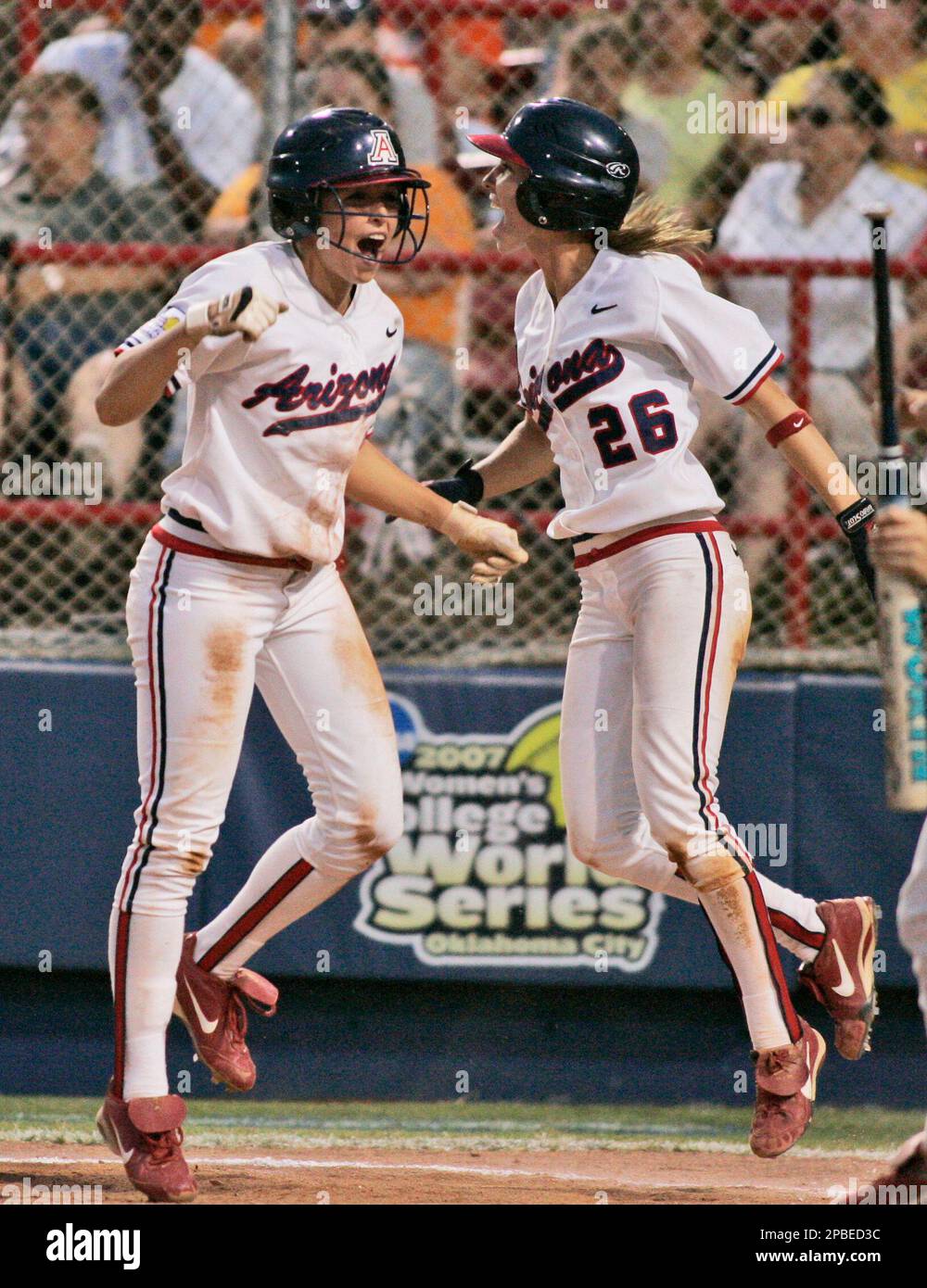 Arizona's K'Lee Arredondo, left, and Caitlin Lowe celebrate after scoring  against Tennessee in the fifth inning of the decisive third game of the  NCAA women's softball College World Series in Oklahoma City,