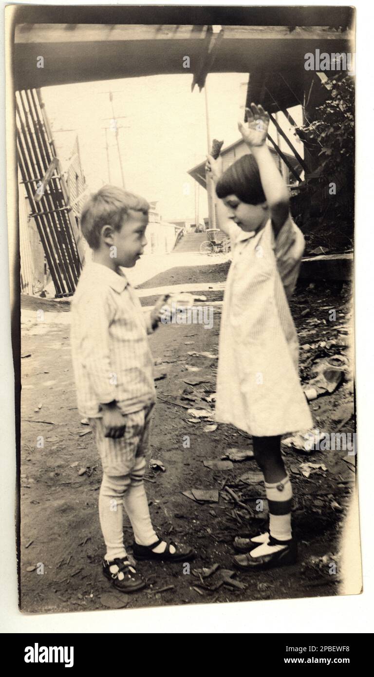 1920 ca, USA : Two brothers or friends play like  GANGSTERN at play with a revolver toy . - TOYS - giocattolo - giocattoli  - FOTO STORICHE - HISTORY PHOTOS  -  GIOCO - sister and brother - - bebé - BAMBINO - BAMBINI - CHILD - CHILDREN  - BABY - ANNI VENTI - 20's - '20  - ODDITY - FOTO NON PROFESSIONALE - SPONTANEA - fotografo amatoriale - FUN - FUNNY - buffo - divertimento - STRANEZZA - hands up - robbery - RAPINA - GIOCO - pistola - pistol - gun - arma - fratello e sorella - amici - friends - mani in alto - rapina -  ---  Archivio GBB Stock Photo