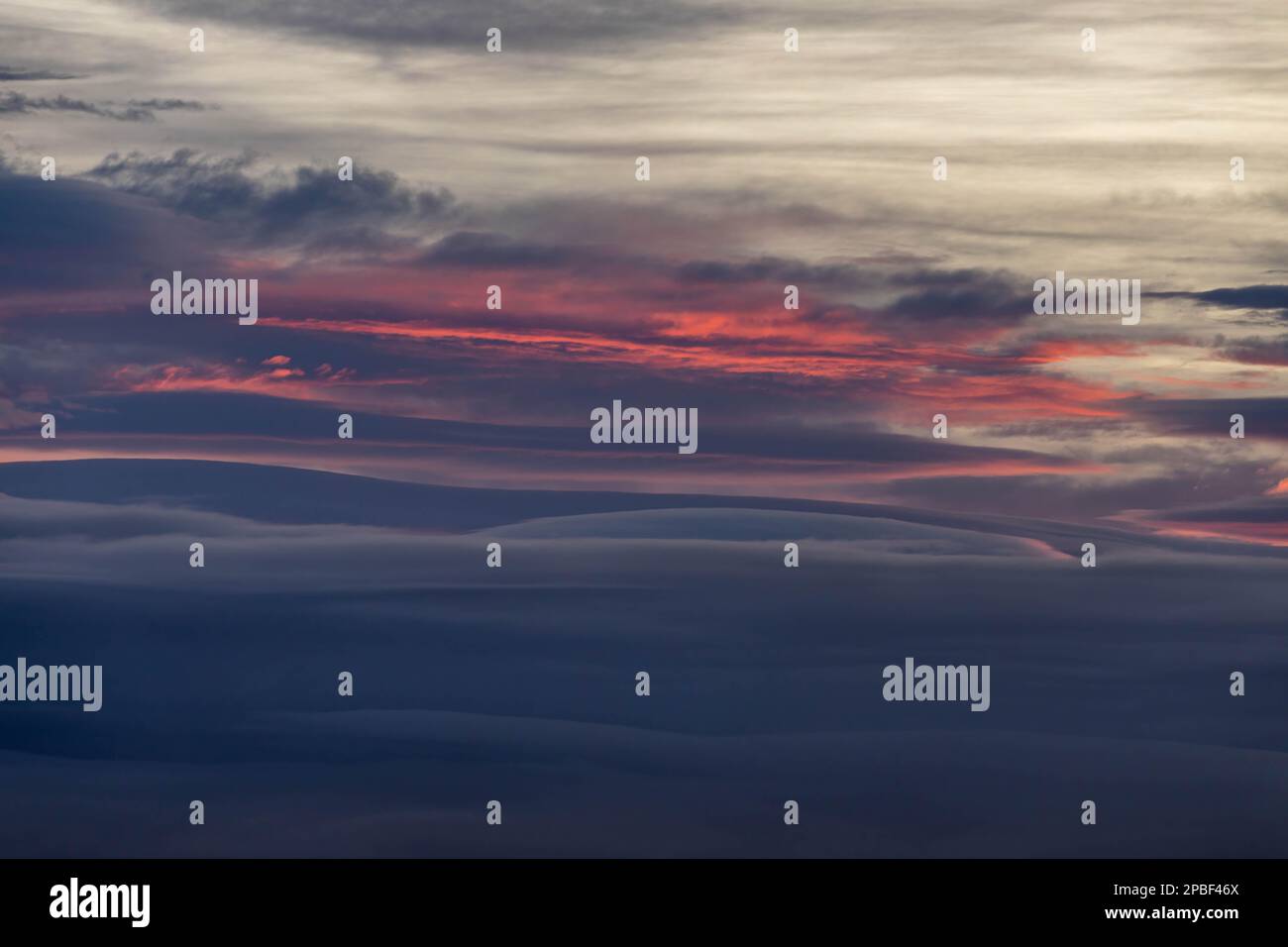 Brilliant colors of fire erupt in layered clouds over Antarctica in the dusk of summer Stock Photo