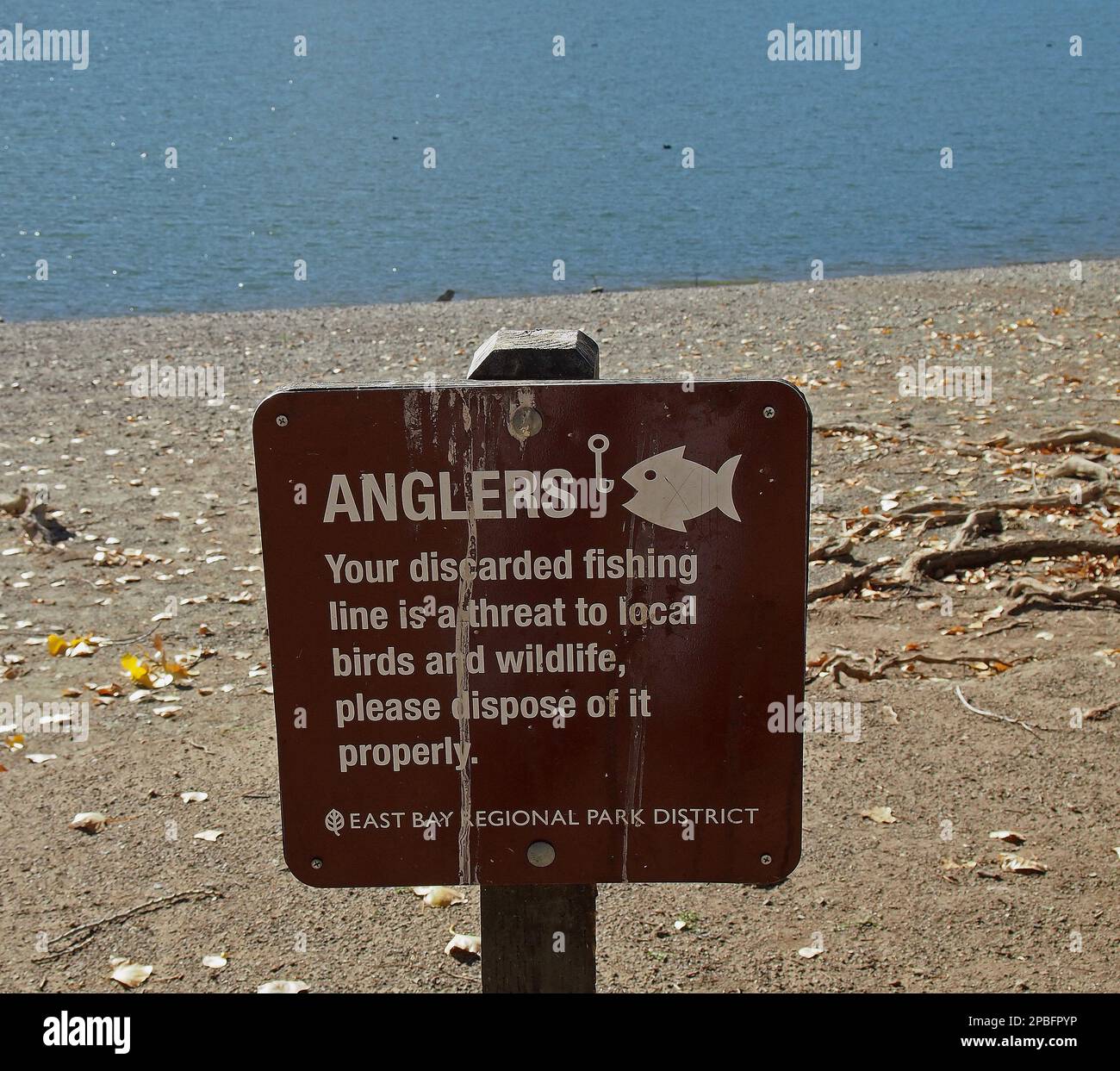 Anglers your discarded fishing line is a threat to local birds and wildlife, please dispose of it properly sign on beach at Lake Del Valle, Livermore, California Stock Photo