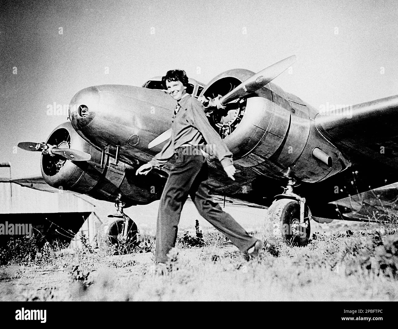 1937 ca , USA  :  Portraits of  most celebrated woman aviator AMELIA EARHART ( 1897 - 1937 ) and Lockheed L-10E Electra NR 16020  . Earhart was the first woman to receive the Distinguished Flying Cross which she was awarded as the first aviatrix to fly solo across the Atlantic Ocean.  She set many other records, wrote best-selling books about her flying experiences, and was instrumental in the formation of The Ninety-Nines, an organization for female pilots.  During an attempt to make a circumnavigational flight of the globe in 1937, Earhart disappeared over the central Pacific Ocean near Howl Stock Photo