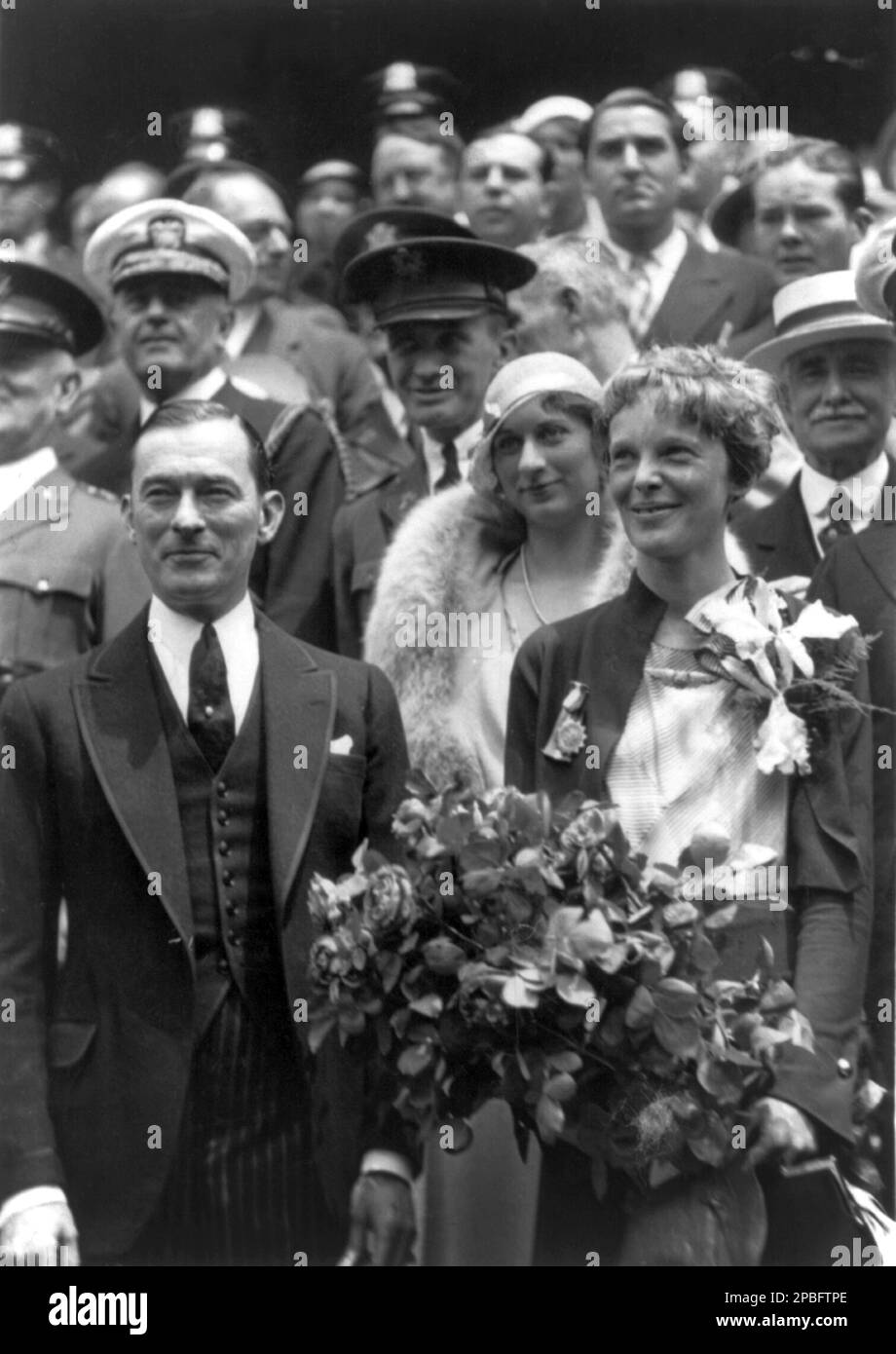 1932 , New York , USA  :  The  most celebrated woman aviator AMELIA EARHART ( 1897 - 1937 ) with Mayor JAMES WALKER of New York. Photo by by Samuel O. Bancroft  . Earhart was the first woman to receive the Distinguished Flying Cross which she was awarded as the first aviatrix to fly solo across the Atlantic Ocean.  She set many other records, wrote best-selling books about her flying experiences, and was instrumental in the formation of The Ninety-Nines, an organization for female pilots.  During an attempt to make a circumnavigational flight of the globe in 1937, Earhart disappeared over the Stock Photo