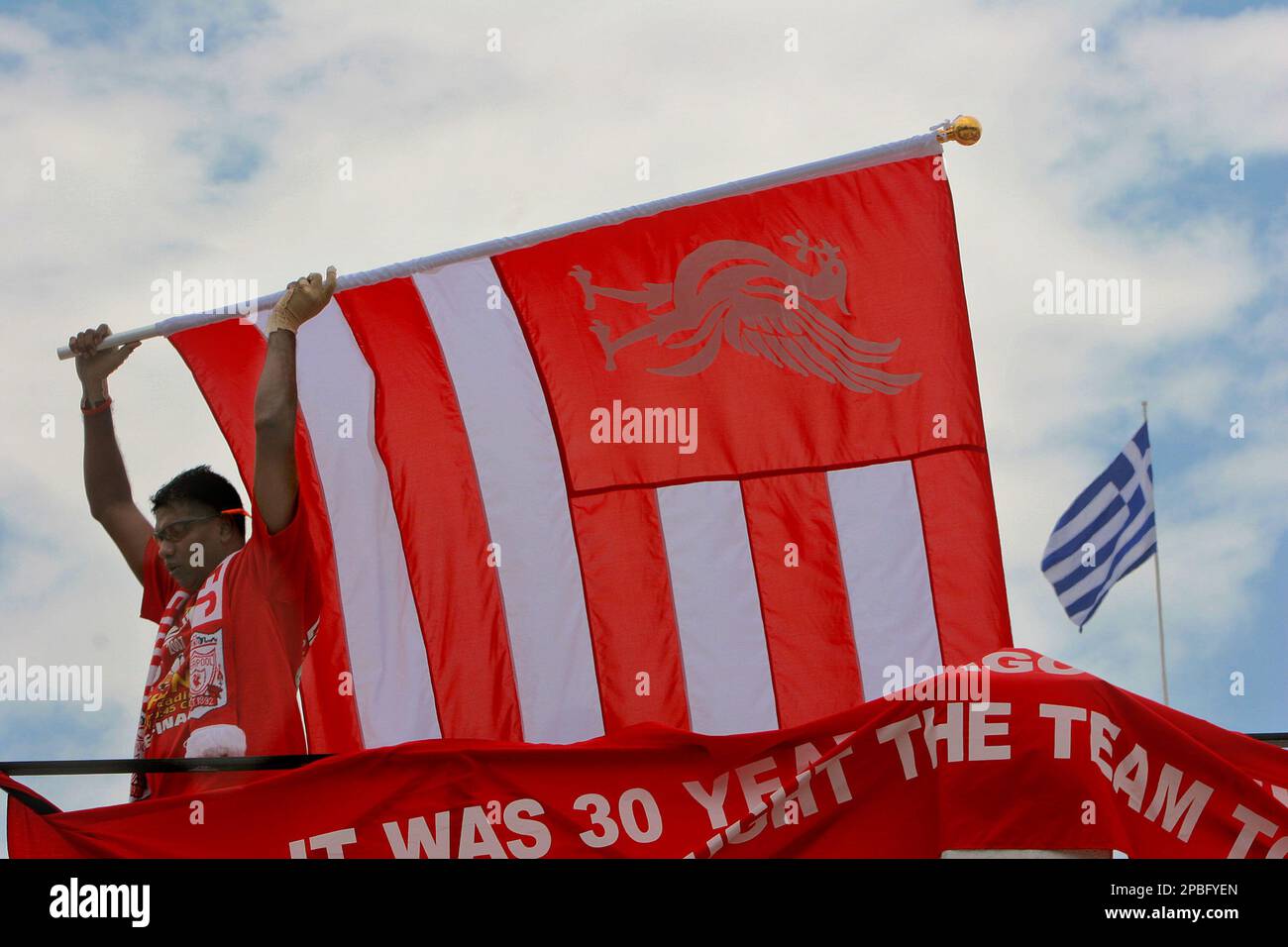 A Liverpool supporter waves a flag in front of a parliament house, see the  Greek flag left, at the Syntagma square in Athens, Greece, Tuesday, May 22,  2007. Liverpool faces Italy's AC