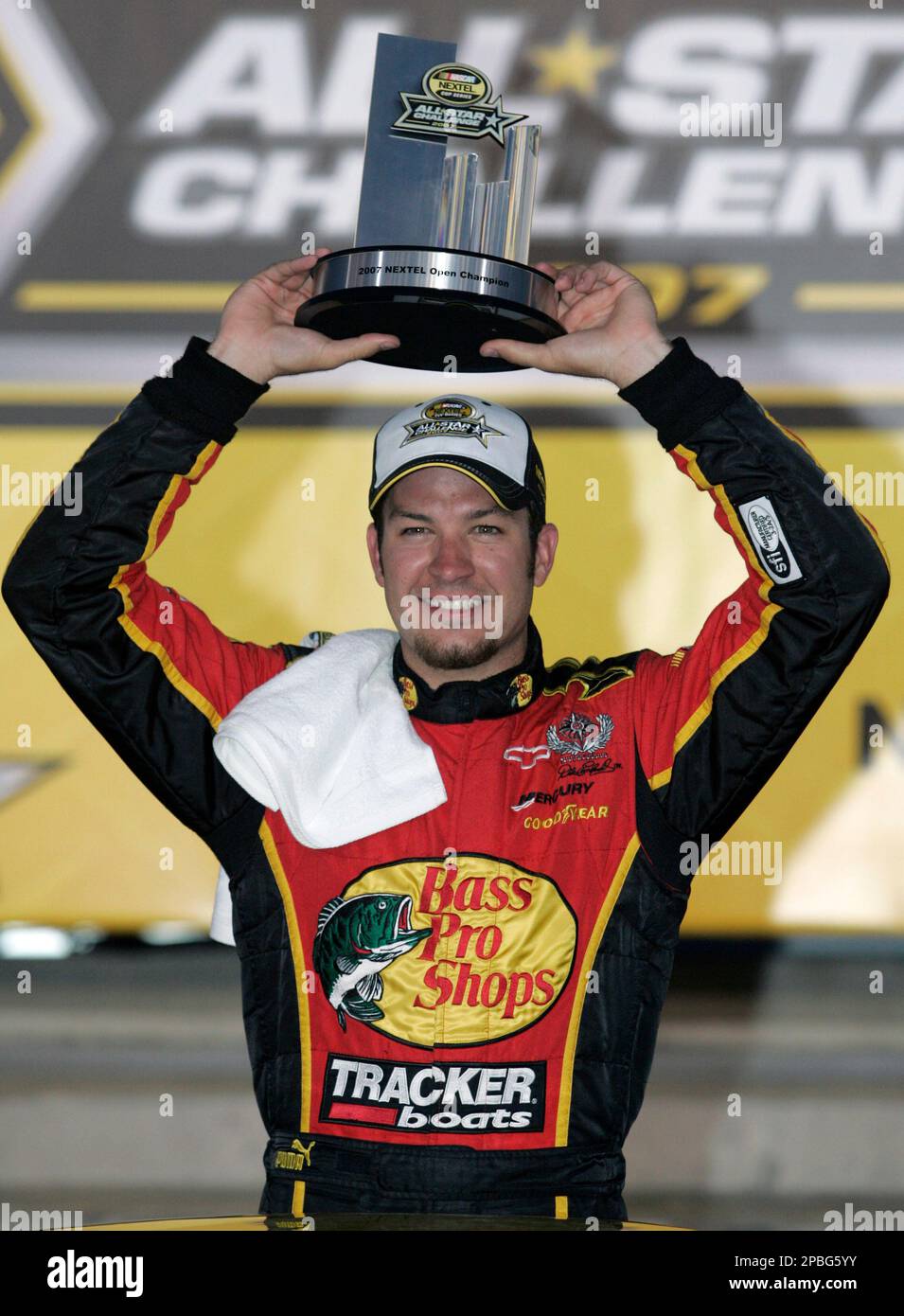 Martin Truex Jr raises the trophy after winning the Nextel Open race