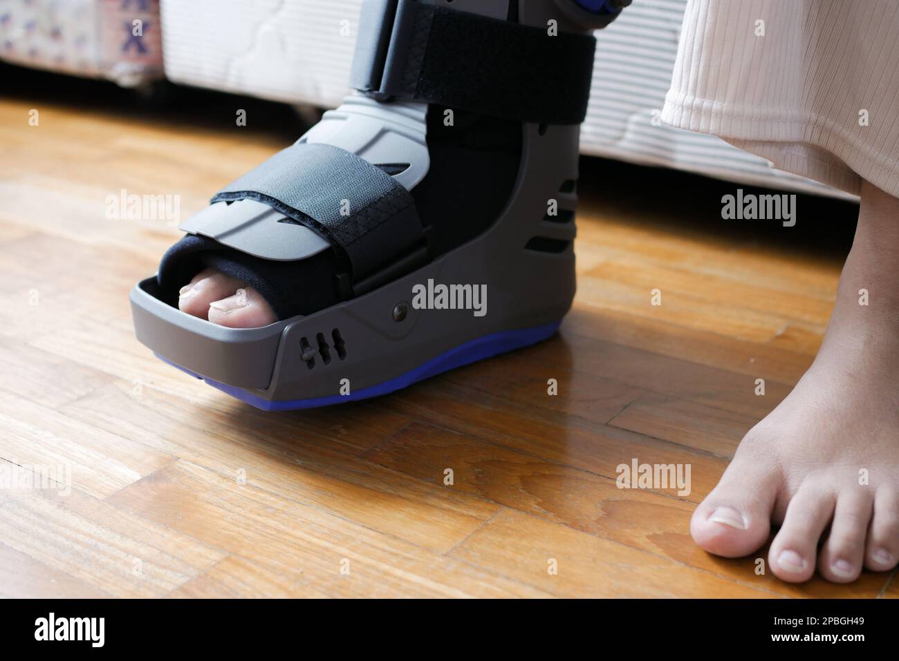 women broken feet with a grey plastic boot ankle brace injury protecting boot Stock Photo Alamy