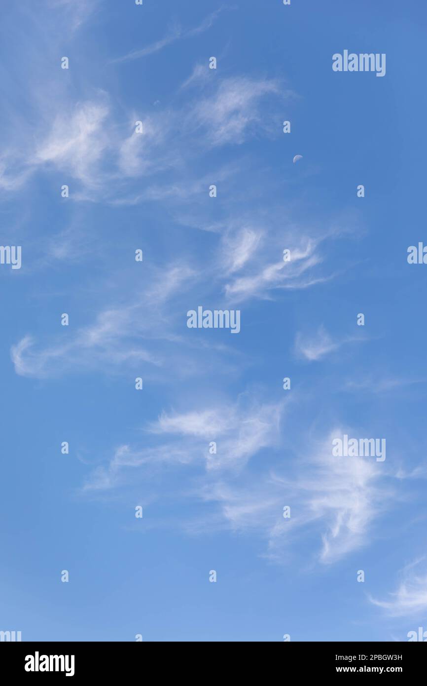 Clouds and moon against a beautiful blue sky Stock Photo