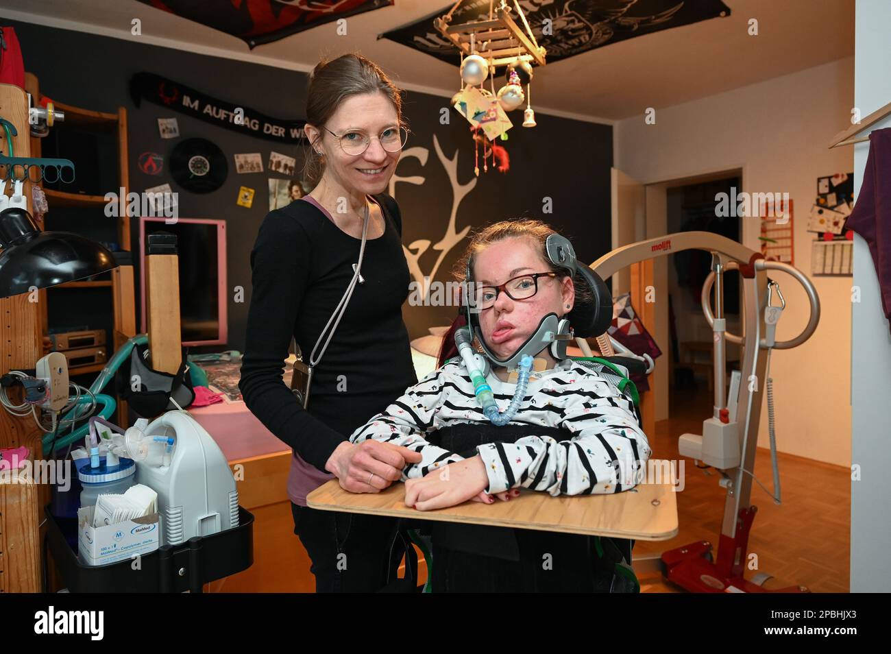 Kassel, Germany. 08th Mar, 2023. Anna-Lena (r) sits next to her mother Bettina Ditschar in her room in a wheelchair. She suffers from spinal muscular atrophy. She is dependent on help around the clock and fears that she will soon no longer be allowed to live at home on the basis of a new law on intensive care. (to dpa 'Affected persons and doctors criticize new law on intensive care') Credit: Uwe Zucchi/dpa/Alamy Live News Stock Photo