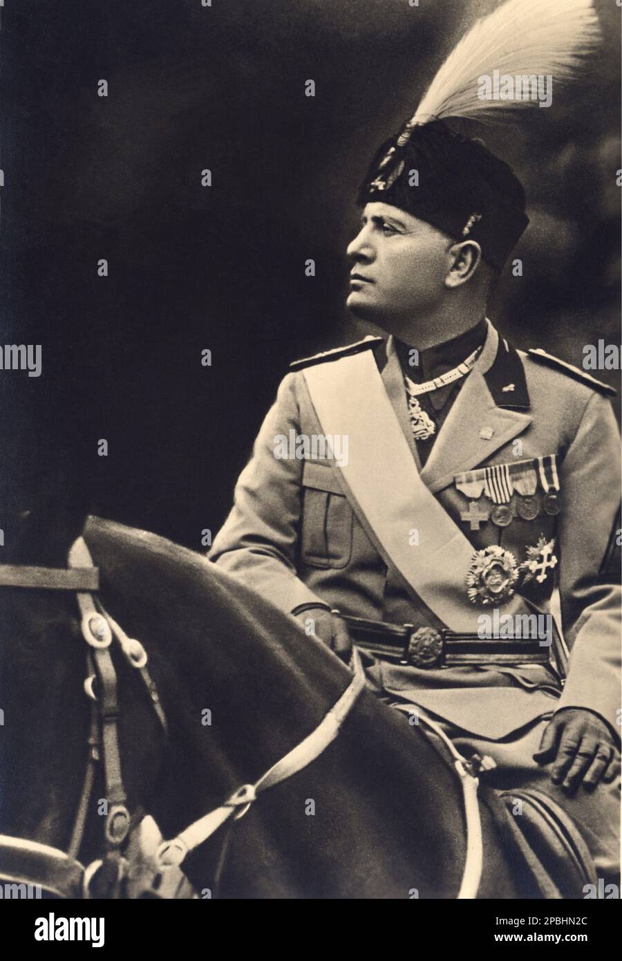 1937 ca. , Roma , Italy : The italian Fascist Duce BENITO MUSSOLINI at time of proclamation of the Impero d' Italia  - ritratto - portrait - POLITICA - POLITICO -  ITALIA - POLITIC - portrait - ITALY - FASCISMO - FASCISM - FASCISTA - military uniform - divisa - uniforme militare - feathers - piume - hat - cappello - medails - medaglia - medaglie - collare dell' Annunziata - WWII - SECONDA GUERRA MONDIALE - 2nd - COLOSSEO - ROME - ITALIA - guanti - gloves - horse - cavallo   ----  Archivio GBB Stock Photo