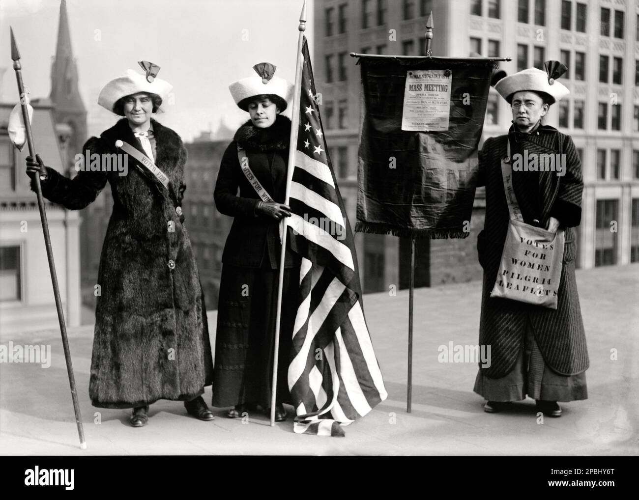 1915 ca , New York , USA :  Photo shows women suffrage hikers General Rosalie Jones, Jessie Stubbs, and Colonel Ida Craft, who is wearing a bag labeled ' Votes for Women pilgrim leaflets' and carrying a banner with a notice for a ' Woman Suffrage Party . Mass meeting. Opera House. Brooklyn Academy of Music. January 9th at 8:15 p.m. ' with speakers Rev. Anna Shaw, Mrs. Carrie Chapman Catt, and Max Eastman - SUFFRAGETTA - sufraggetta - Sufragist - POLITICO - POLITICIAN - POLITICA - POLITIC - FEMMINISMO - FEMMINISTA  - FEMMINISTE - SUFFRAGETTE - USA - ritratto - portrait   - UNITED STATES  FLAG - Stock Photo