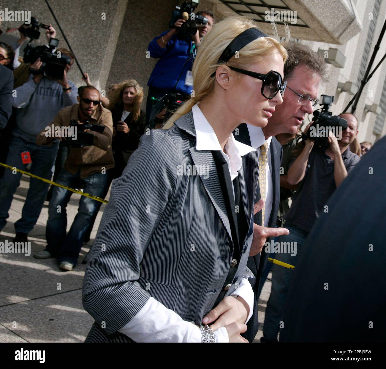 Paris Hilton is escorted by her father Rick out of the Los Angeles