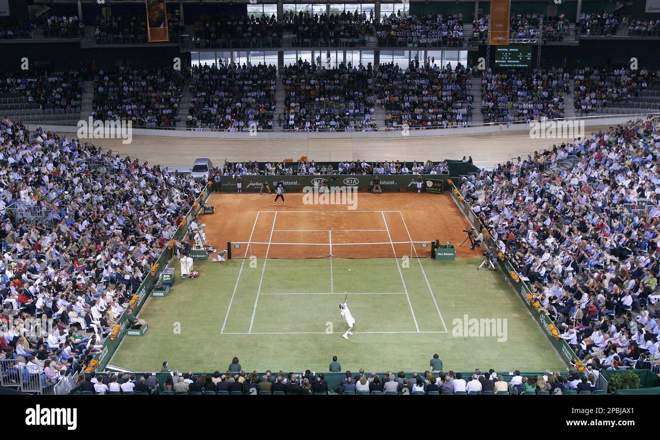 Four-time Wimbledon champion Roger Federer, bottom, servers to two-time  French Open winner Rafael Nadal during an exhibition tennis match on a  customized half-clay, half-grass court on Palma de Mallorca, Spain,  Wednesday, May
