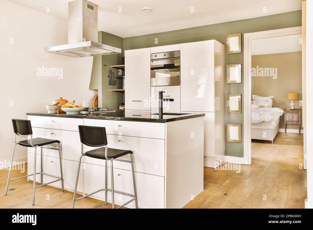 a kitchen with two bar stools in front of the counter and an open door  leading to the living room Stock Photo - Alamy, image size:1300x956