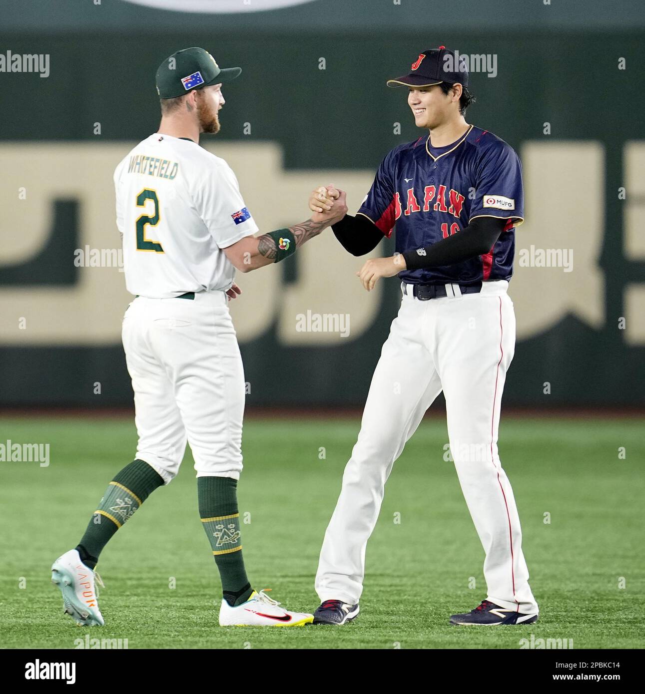 Los Angeles Angels teammates Japan's Shohei Ohtani (R) and Australia's Aaron Whitefield shake