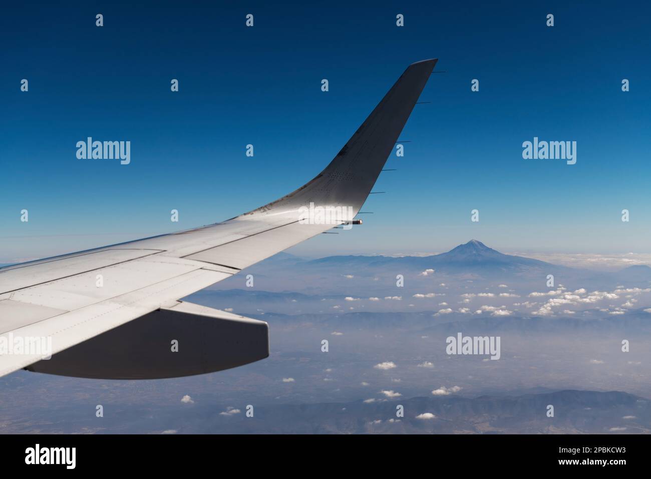 Pico de Orizaba or Citlaltepetl volcano, highest mountain peak of Mexico, seen from airplane with wing. Stock Photo