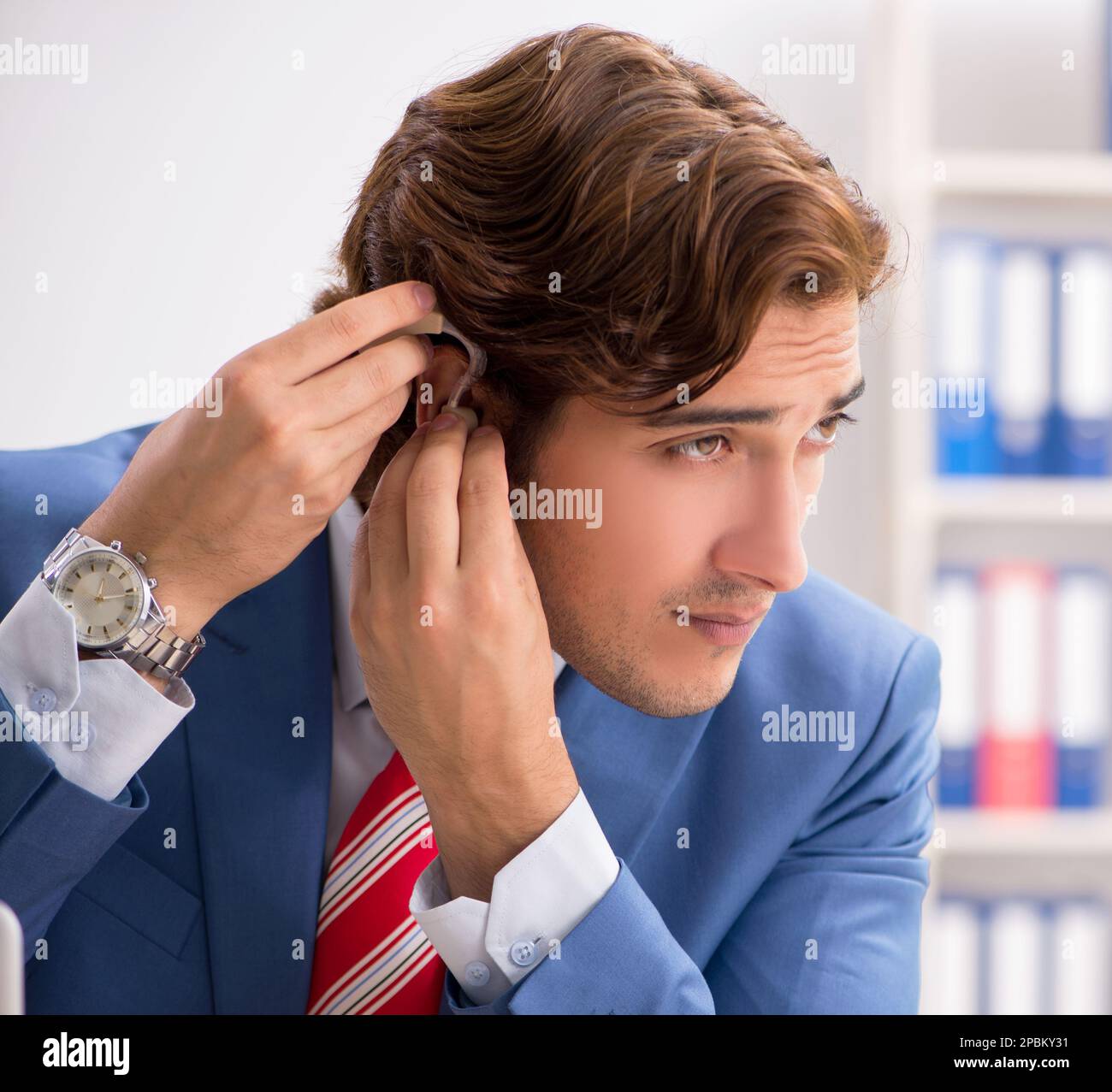 Deaf employee using hearing aid in office Stock Photo Alamy