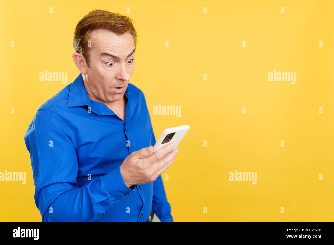 Surprised mature man looking at the mobile phone Stock Photo