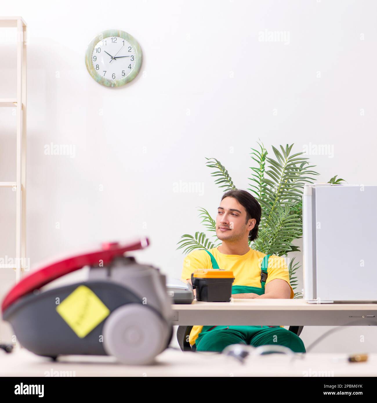 The man repairman repairing vacuum cleaner and fridge Stock Photo Alamy