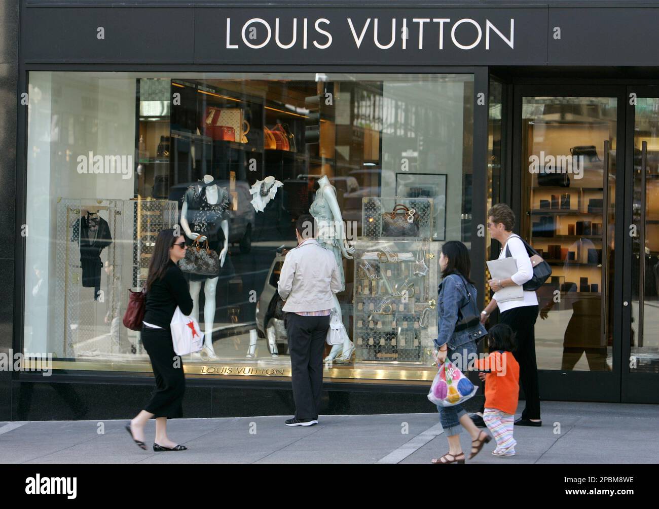 Shoppers walk past the Louis Vuitton store at Union Square in San