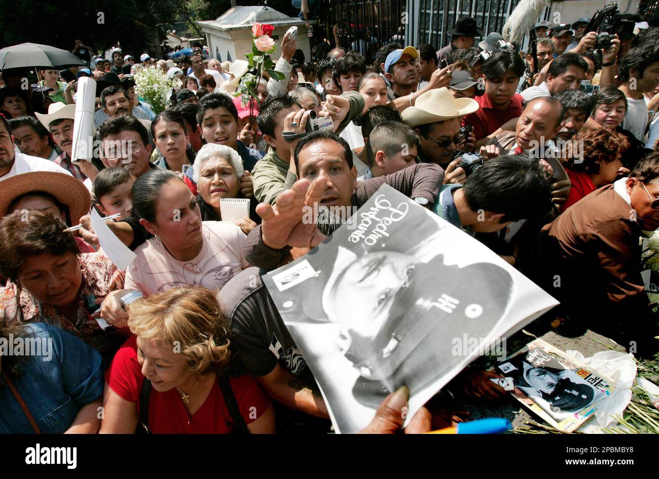 A man tries to reach an image of Pedro Infante at his grave in 