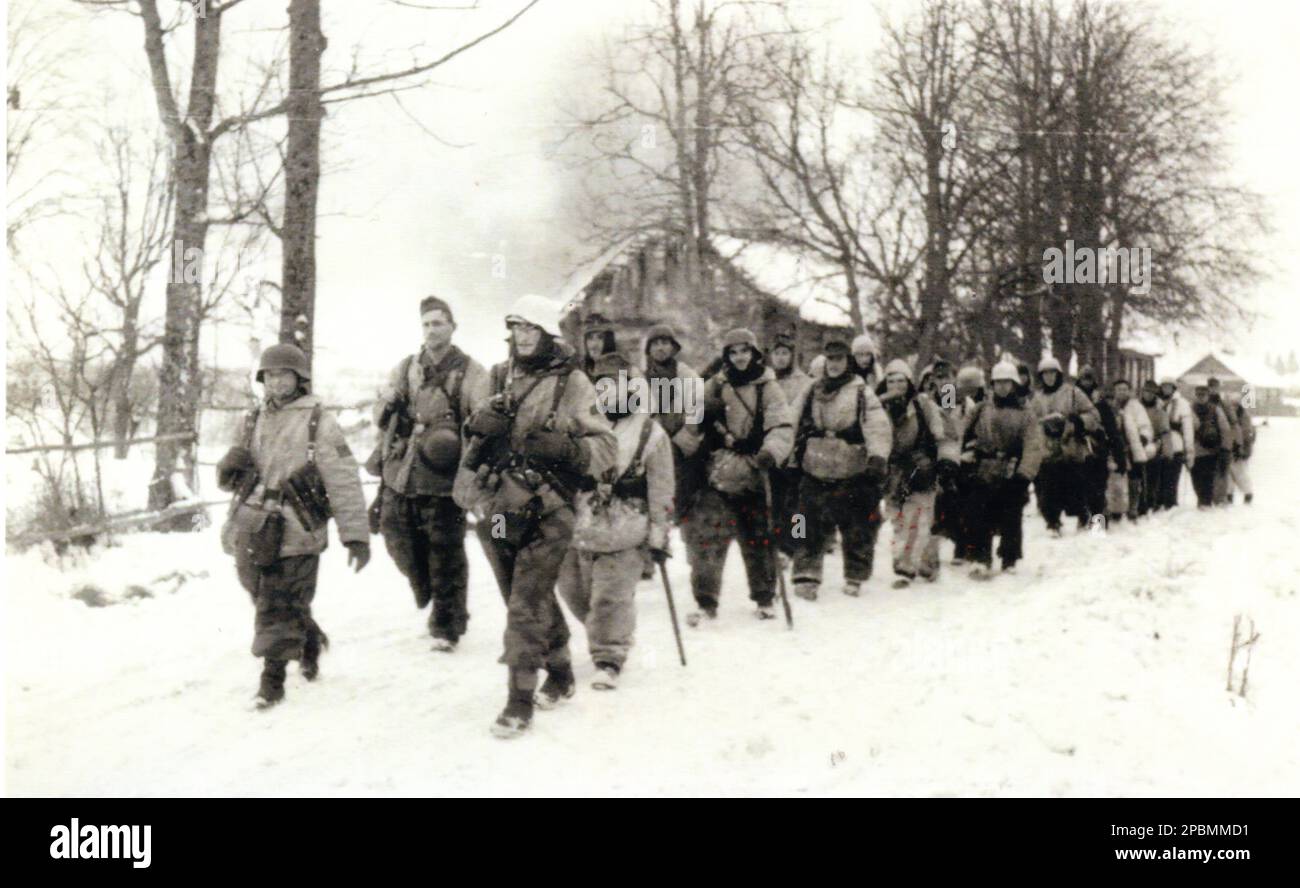 World War Two B&W Photo Wehrmacht Troops move towards the Front line on the Russian Front during the Winter of 1943/44. The German Soldiers are dressed in Snow Camouflage Stock Photo
