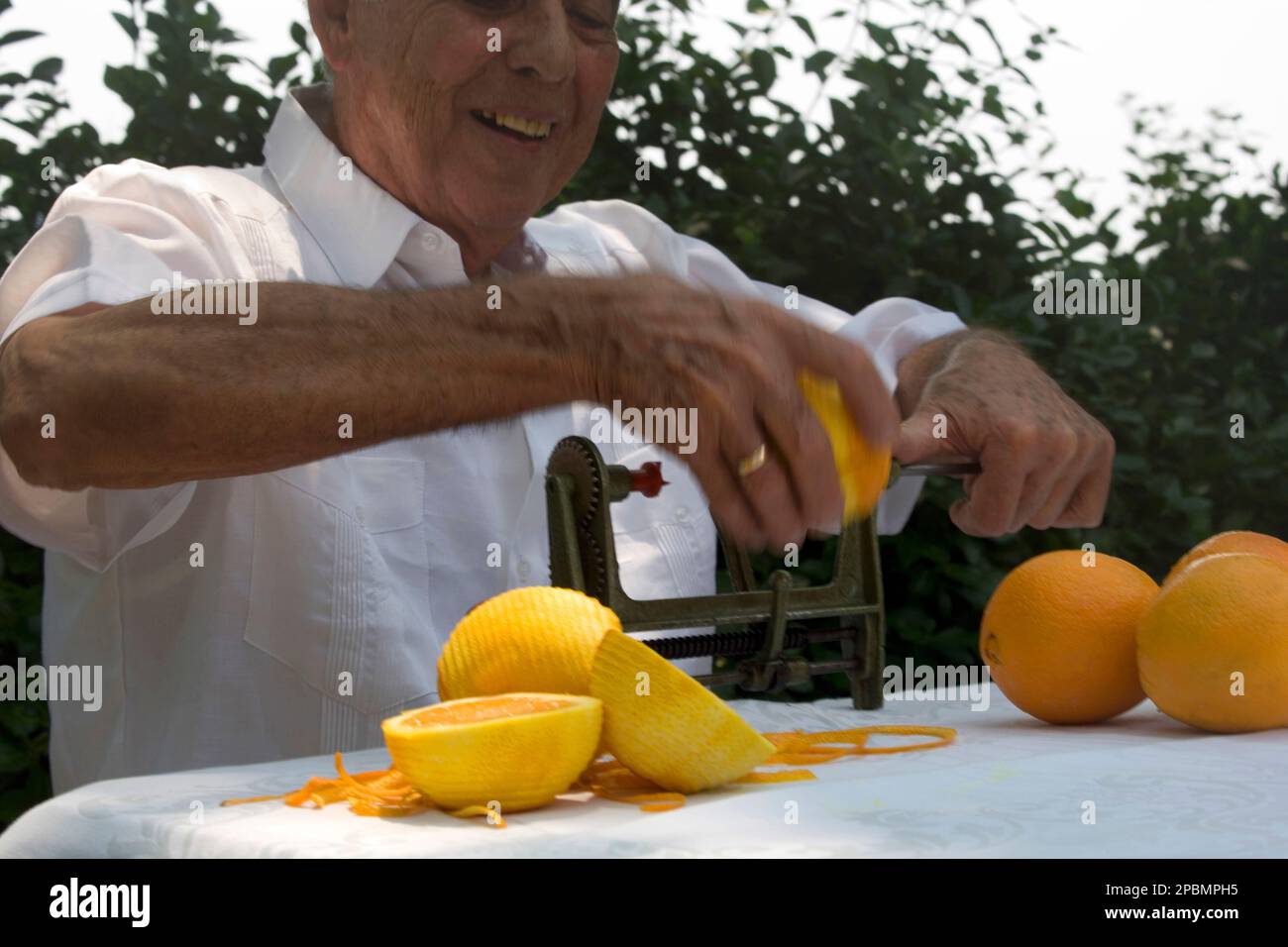 ELDERLY CUBAN MAN PEELING ORANGES MIAMI FLORIDA USA Stock Photo