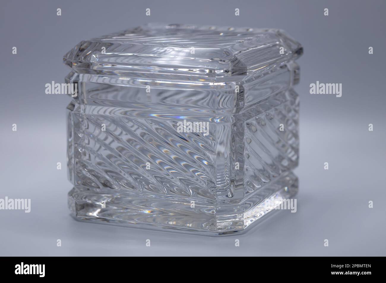 Close up view of a beautiful modern square lead crystal glass box with shimmering diagonal striped lines, reflecting light Stock Photo