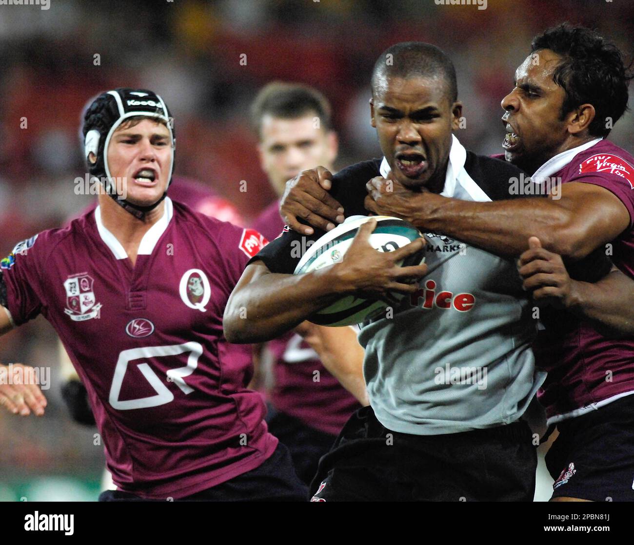 South African Sharks JP Pietersen, center, is tackled by 