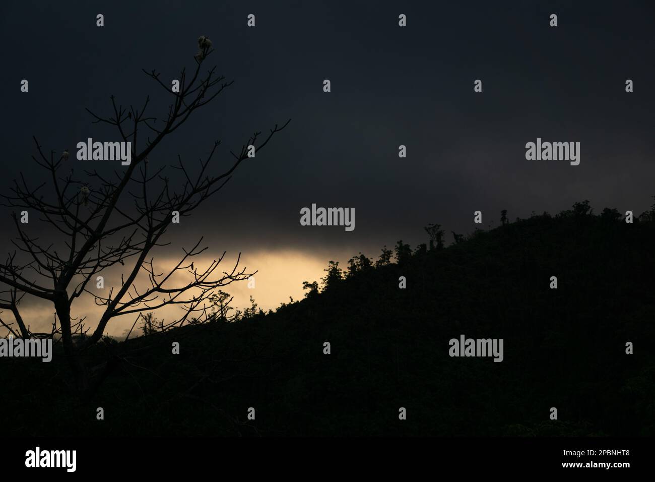 The morning sun is rising from the other side of the mountain. The sun is covered in clouds. Photo taken from Chittagong, Bandarban, Bangladesh. Stock Photo