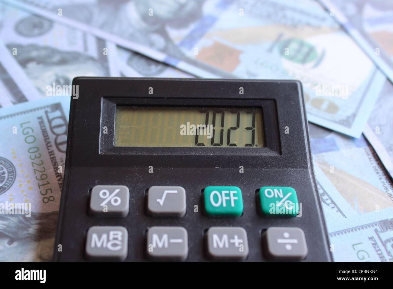 Close up image of money and calculator with number 2023 on display. Financial planning concept Stock Photo