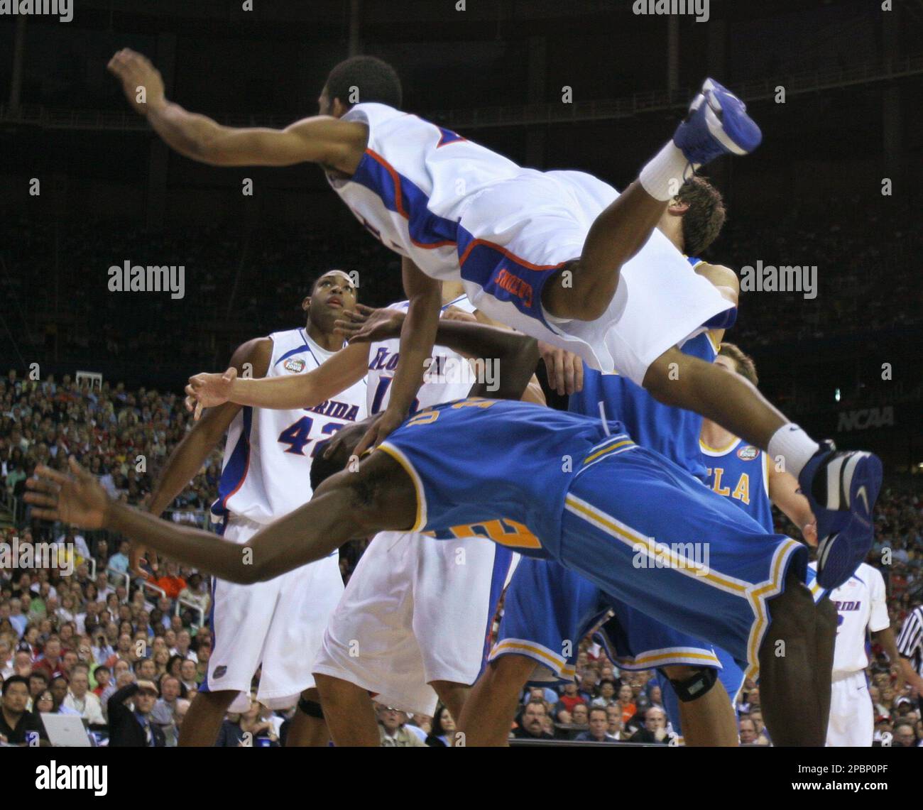 Florida's Taurean Green falls on top of UCLA's Alfred Aboya (12) during