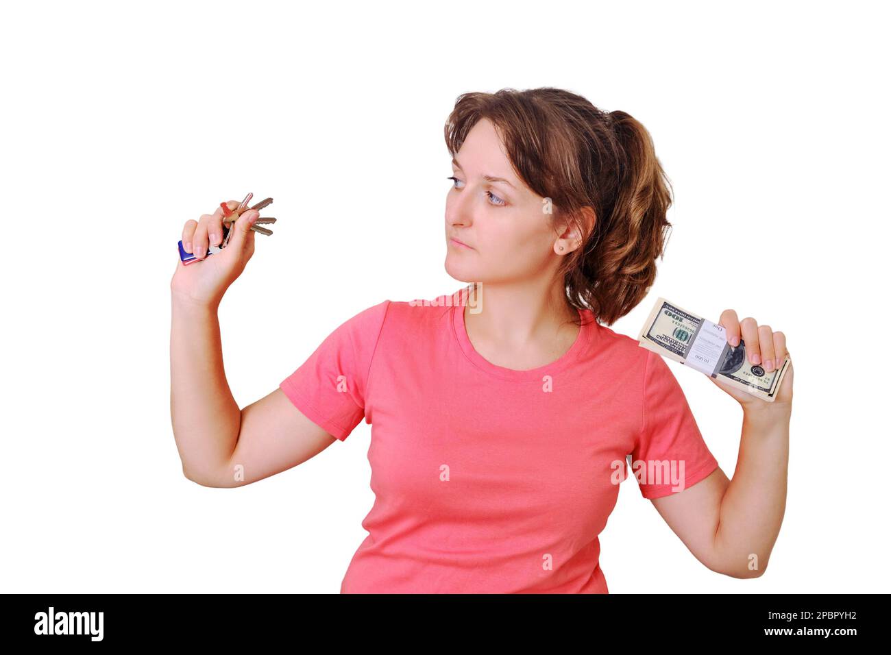 A young woman looks at the keys to the new apartment, isolated on a ...