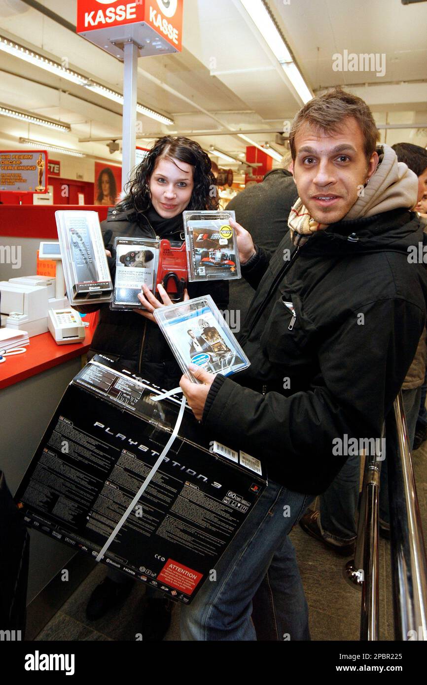 People buy a new Sony Playstation 3, early Friday, March 23, 2007 in  Zurich, Switzerland. The