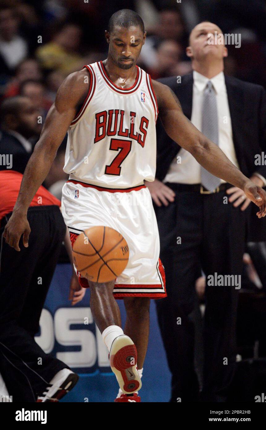 Chicago Bulls' Ben Gordon kicks the ball as coach Scott Skiles looks up at  the scoreboard during a timeout against the Denver Nuggets during the first  quarter of an NBA basketball game