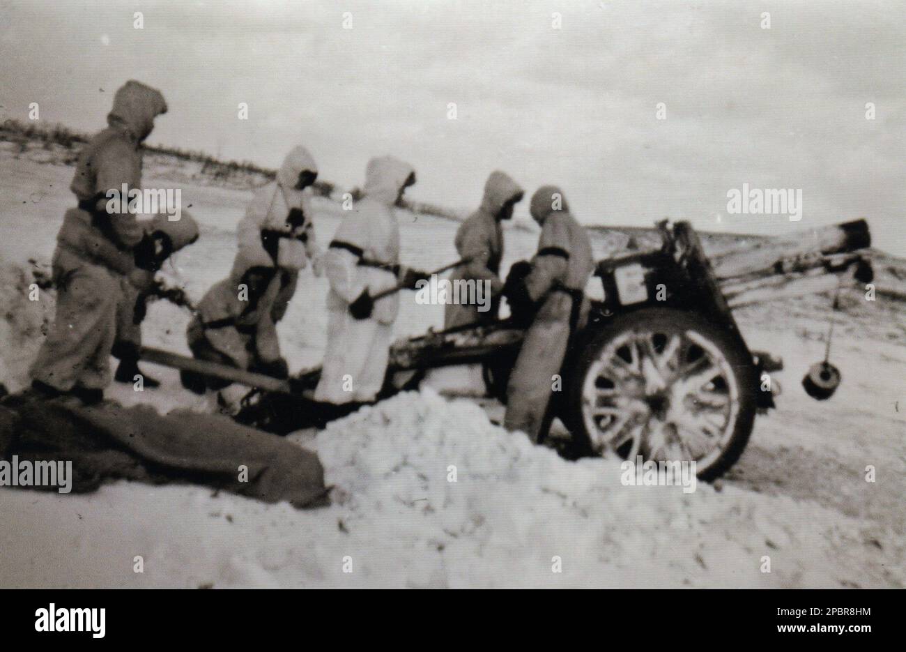 World War Two B&W photo German 15cm Heavy Infantry Gun on the Russian Front 1943 . The German Soldiers are dressed in Snow White Parkas as is the Gun painted White Stock Photo