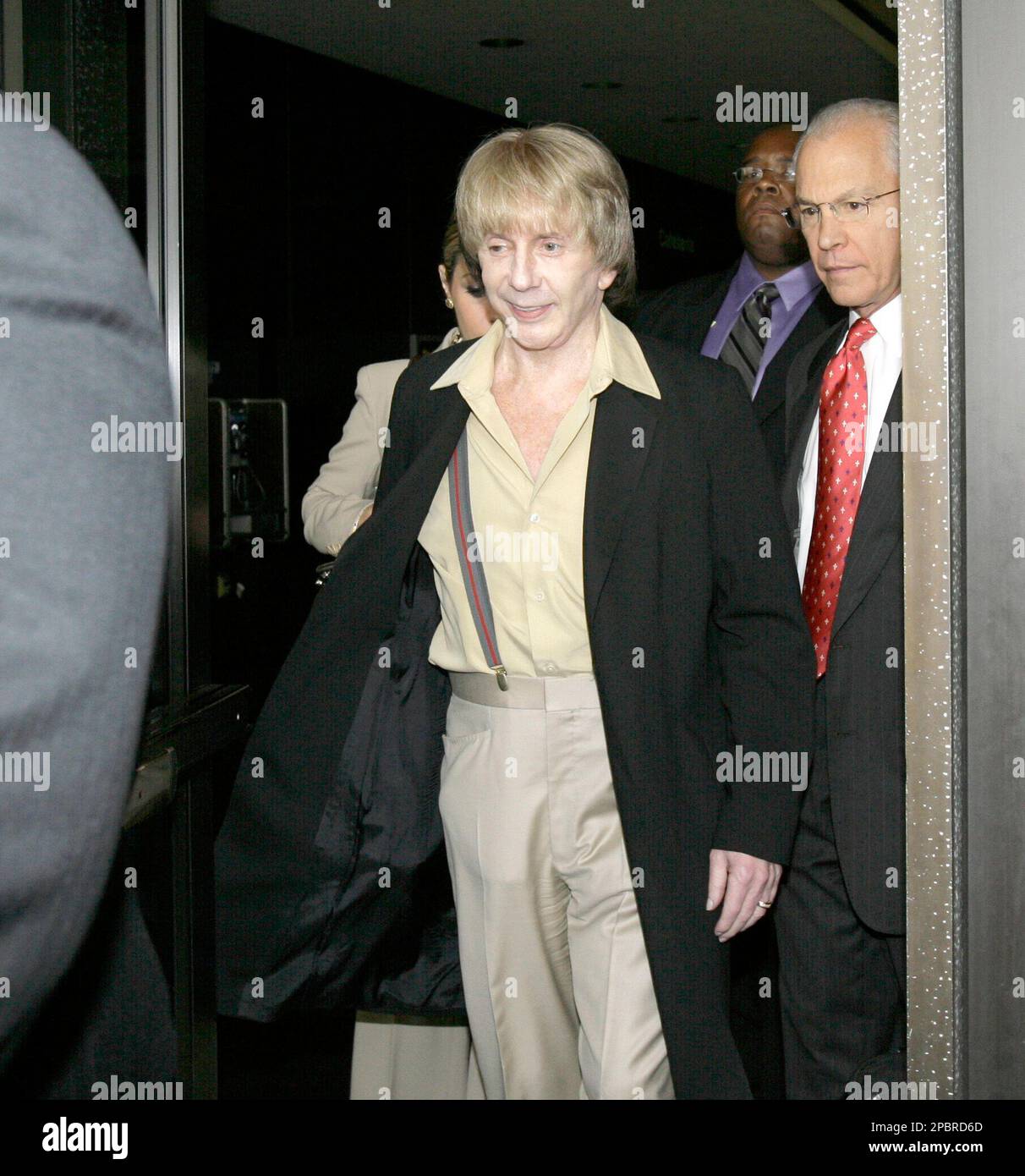 Music producer Phil Spector, left, and his attorney, Roger Rosen, leave