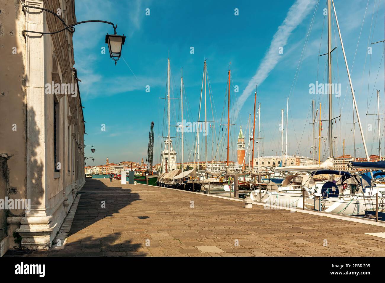View of promenade along small marina with yachts on San Giorgio Maggiore island in Venice, Italy. Stock Photo