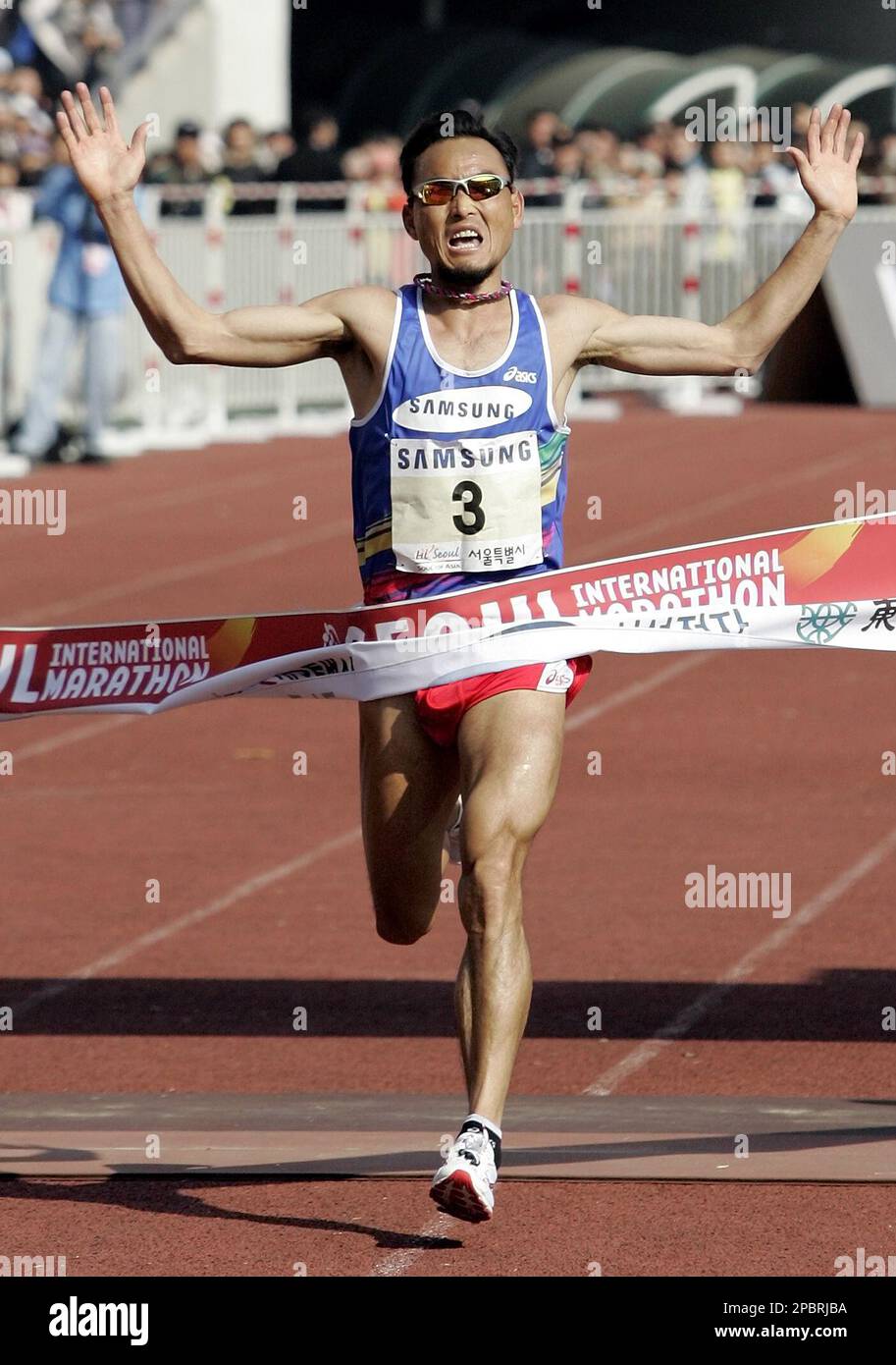 Lee Bong-ju of South Korea raises his arms as he crosses the finish line  during the men's race of the 2007 Seoul International Marathon and the 78th  Dong-A Marathon at Olympic Stadium