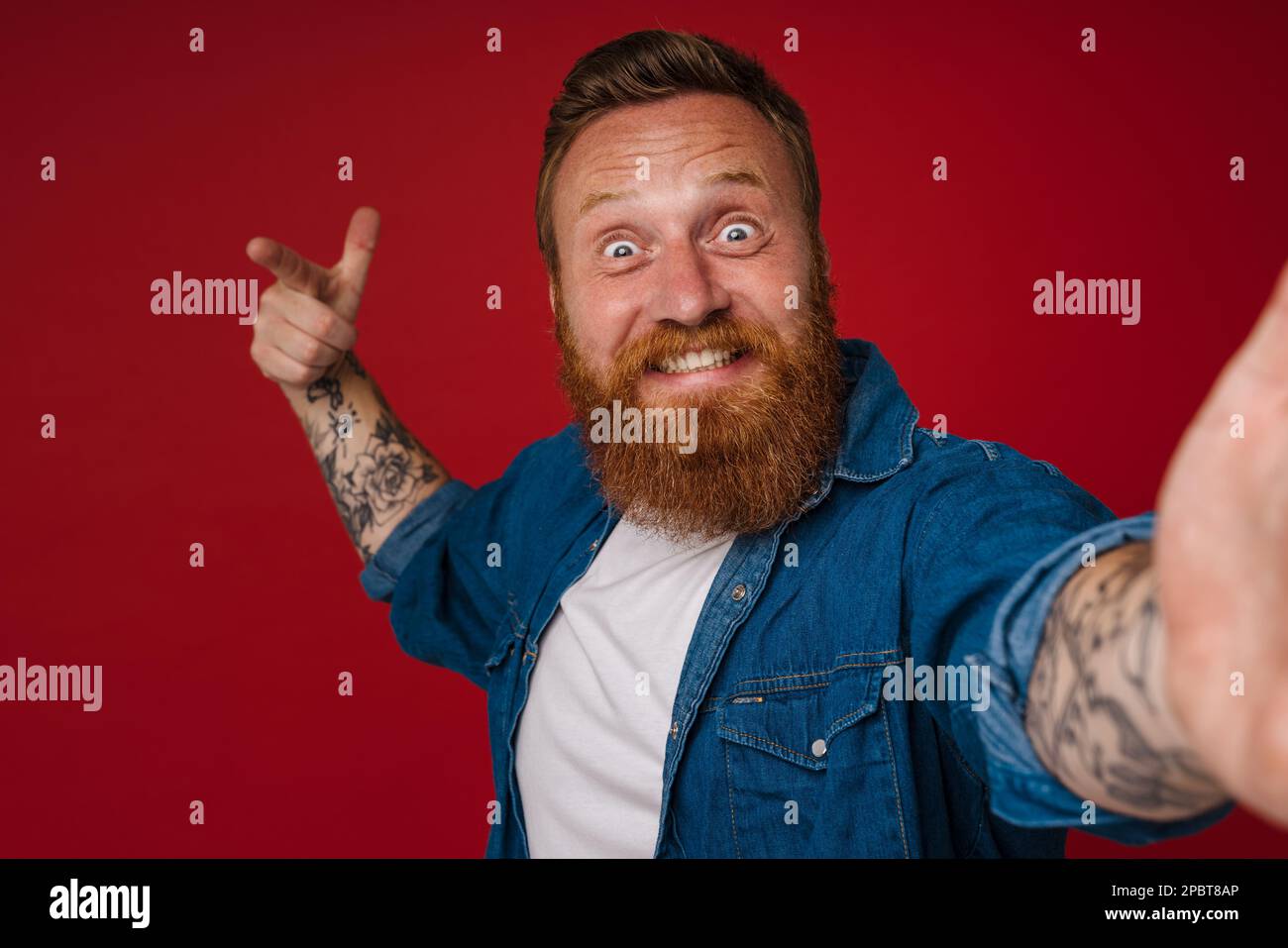 Selfie of adult bearded tattooed handsome enthusiastic redhead man ...