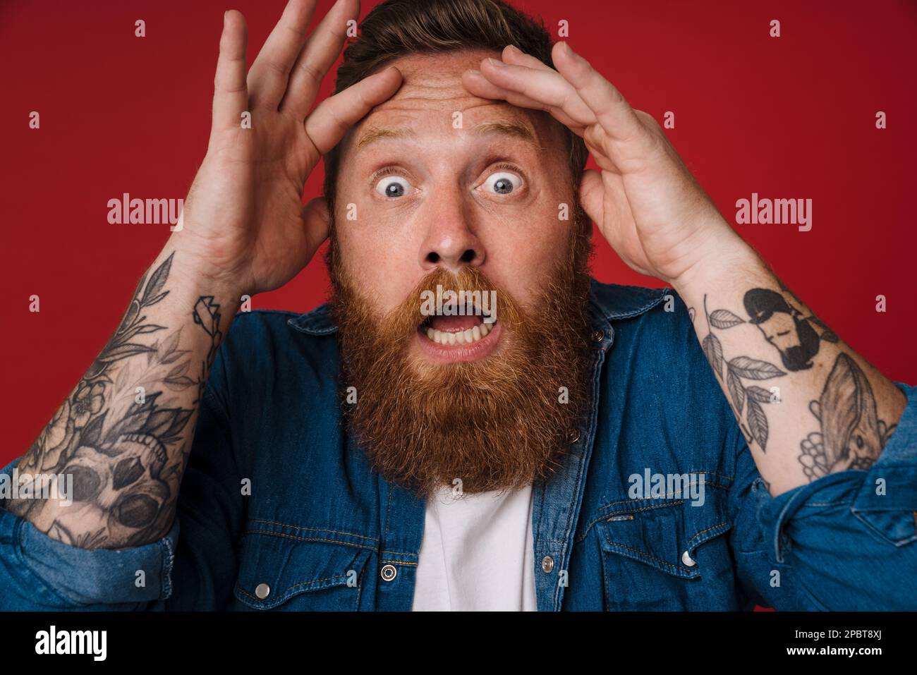Adult bearded tattooed handsome shocked redhead man with opened mouth ...